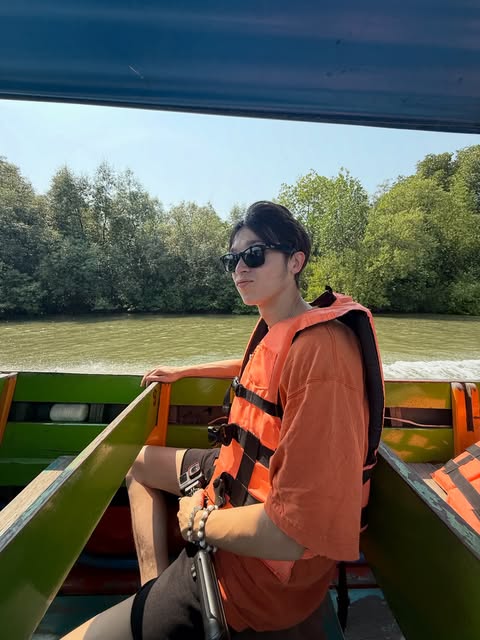 Jed riding a boat on a river in Thailand